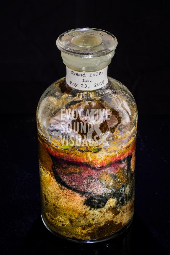 An apothecary bottle from Rick Hannon's sand collection, featuring oil-soaked sand gathered along the south-facing beach of Grand Isle, Louisiana on May 23, 2010, during the height of the BP oil spill. Photo by Richard Alan Hannon