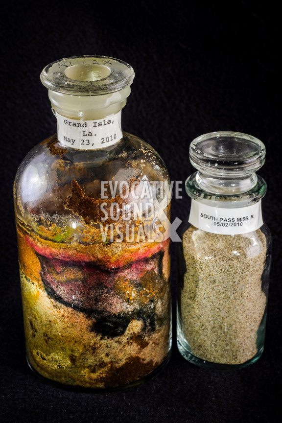 Apothecary bottles from Rick Hannon's sand collection, featuring the oil-soaked sand gathered along the south-facing beach of Grand Isle, Louisiana on May 23, 2010, during the height of the BP oil spill, left, along with sand collected along the Mississippi River at South Pass, 50 miles to the southeast, 21 days earlier. Photo by Richard Alan Hannon