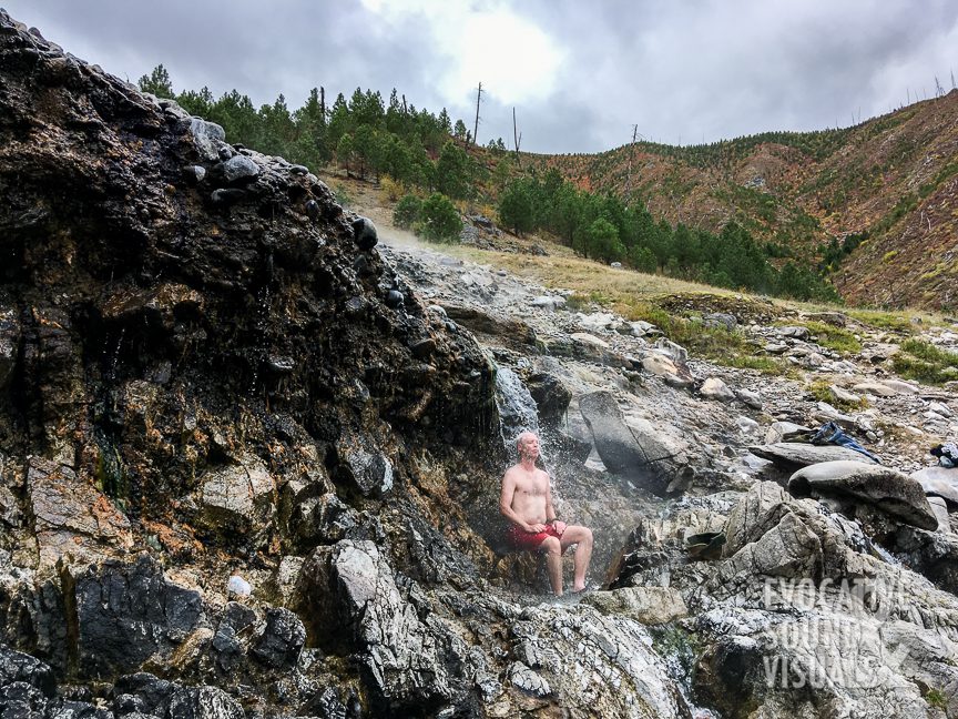 The author soaks beneath a hydrothermal waterfall at Kirkham Hot Springs.