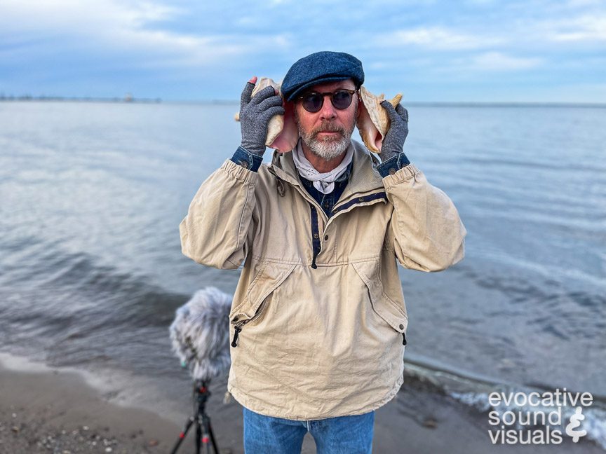 Capturing the sound of gentle waves along Lake Erie at Fairport Harbor Lakefront Park on Saturday, December 16, 2023, as heard through a pair of Queen Conch shells. Photo by Denise Porter